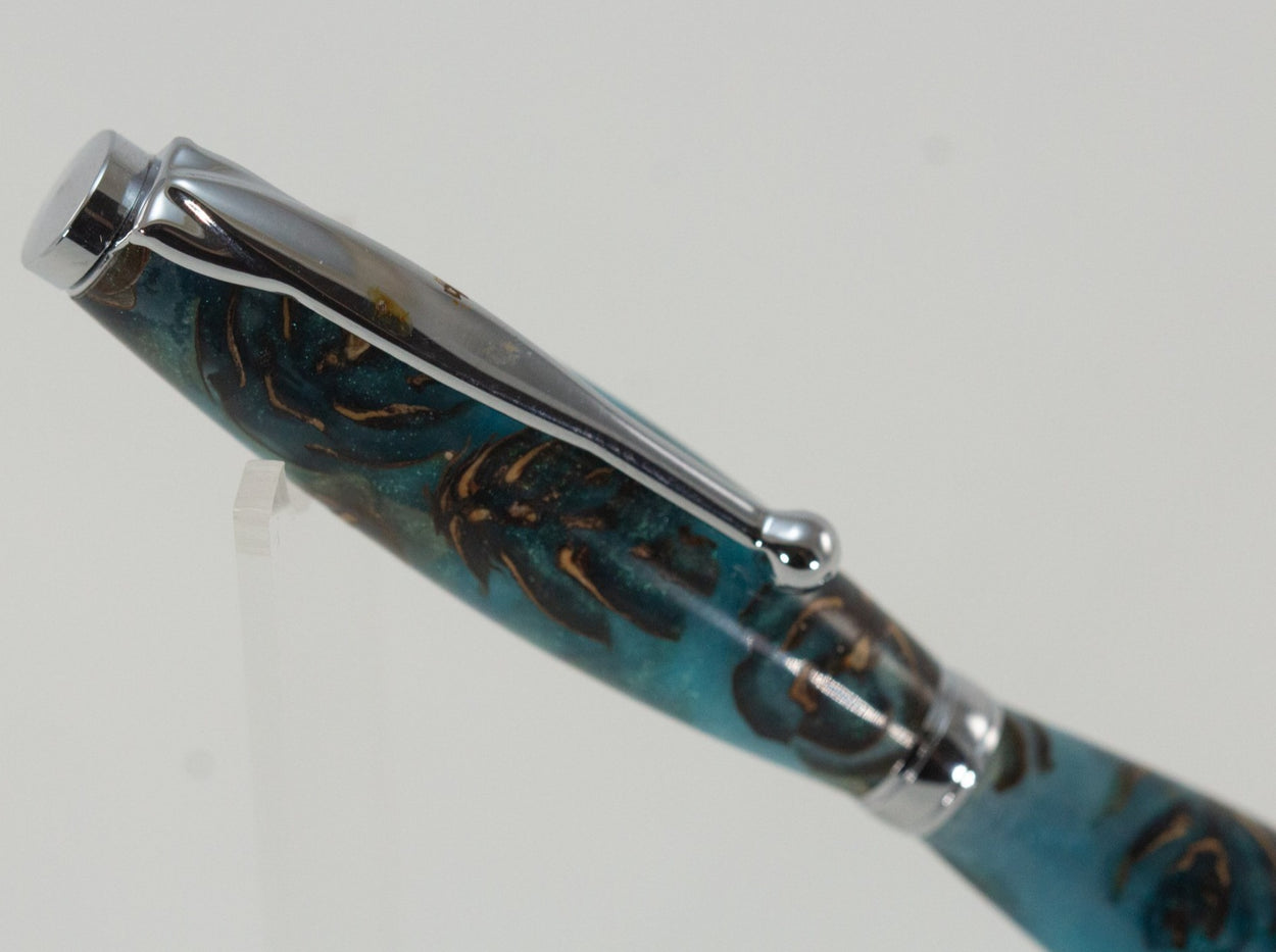 This handcrafted pen is made from (epoxy resin) and pinecones. It provides a firm and comfortable grip. The clip and rings on the cap, barrel, and tip enhance the pen’s beauty. This classic twist pen, the Slimline is an all-time favorite. Quality components like the Swiss-made carbide writing tip make the Slimline pen a fantastic writing choice.